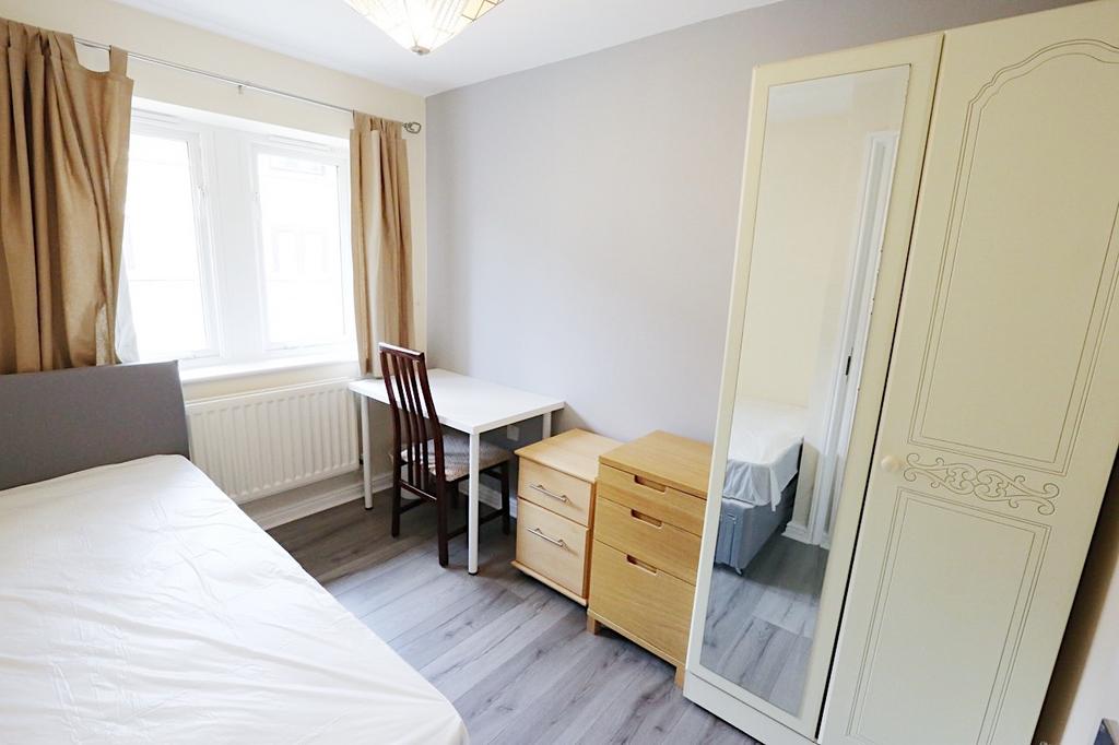Bright, tidy bedroom with a large window, neat ...