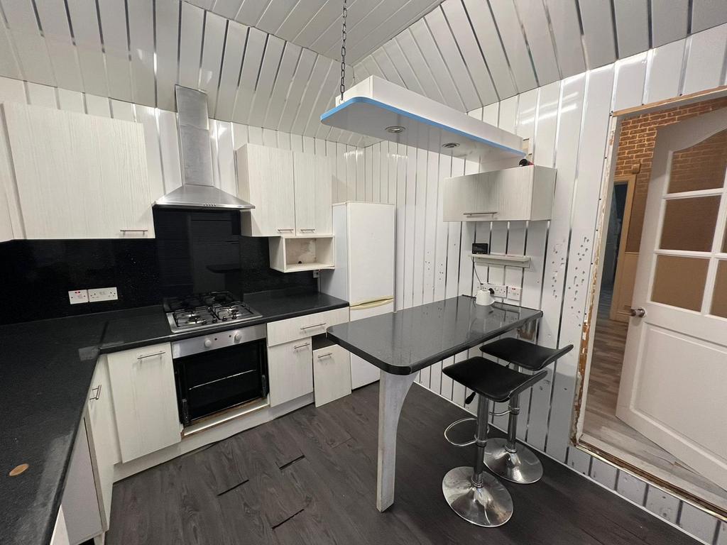 A modern kitchen featuring sleek white cabinetr...