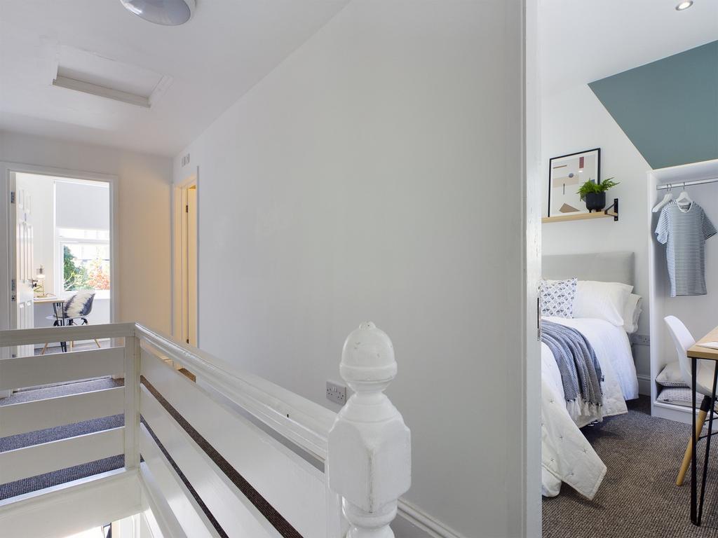 A bright and tidy hallway leading to well-maint...