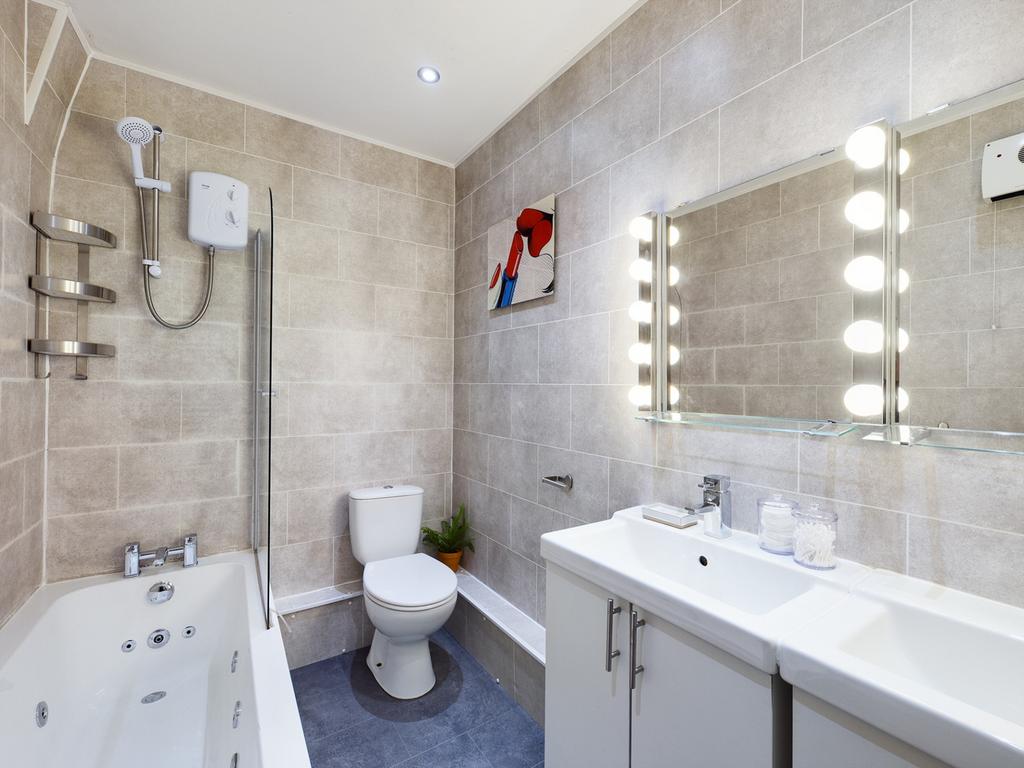 A spacious and modern bathroom featuring a rela...
