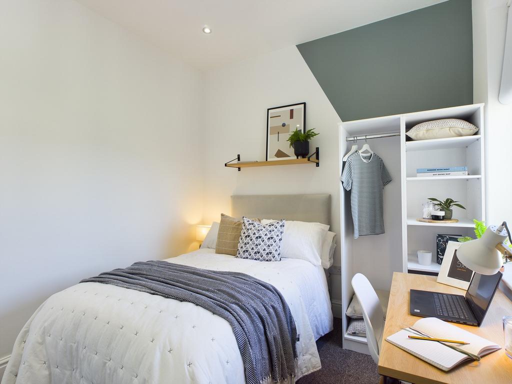 A bright and inviting double bedroom with styli...