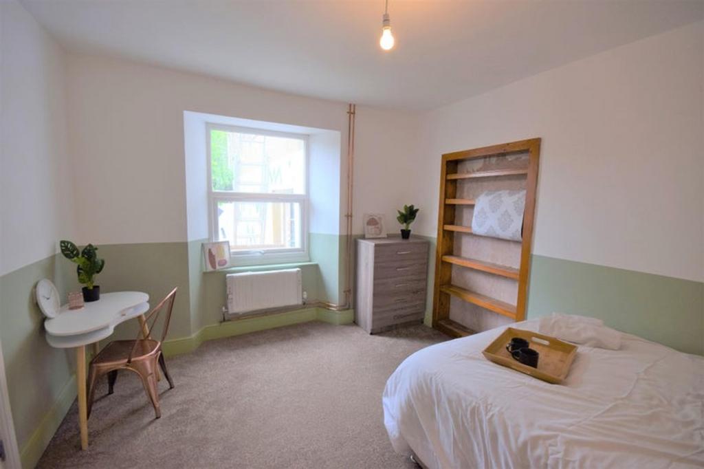 This charming double bedroom features a cozy at...