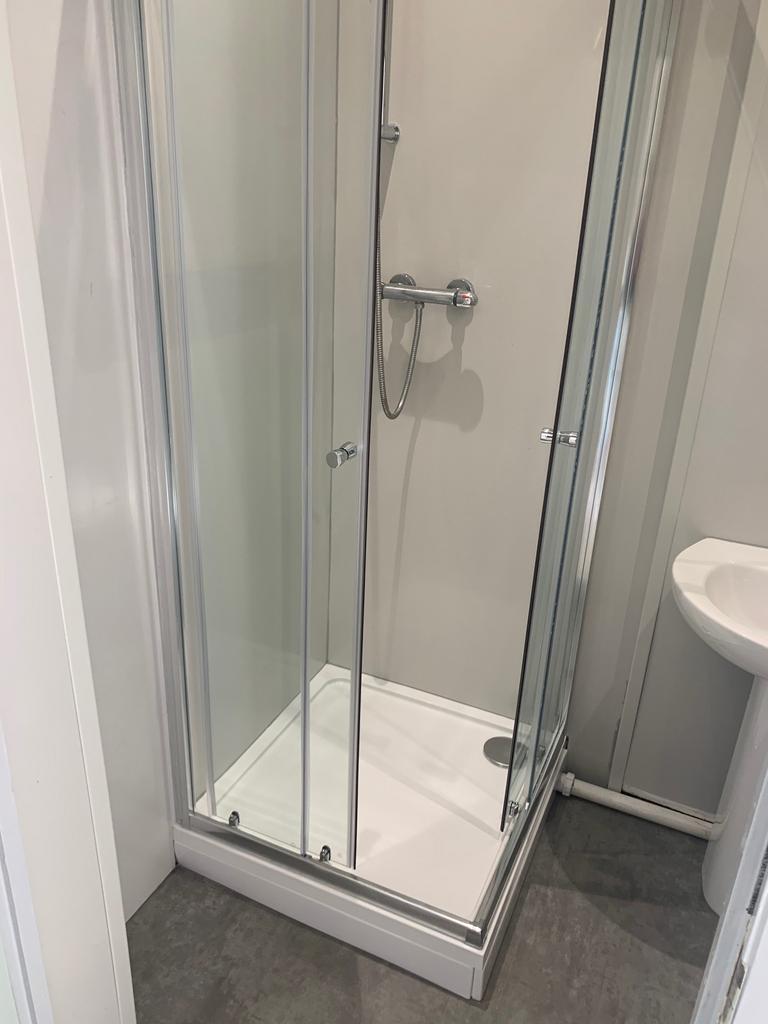 A modern shower area featuring sleek glass pane...