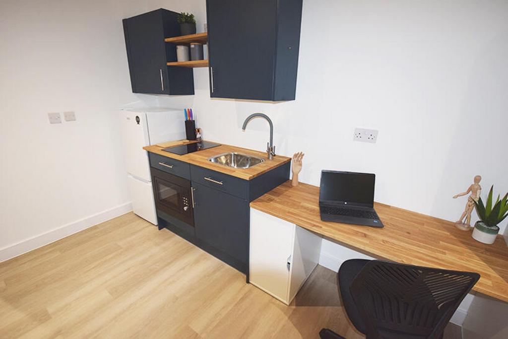 This stylish kitchenette features modern cabine...