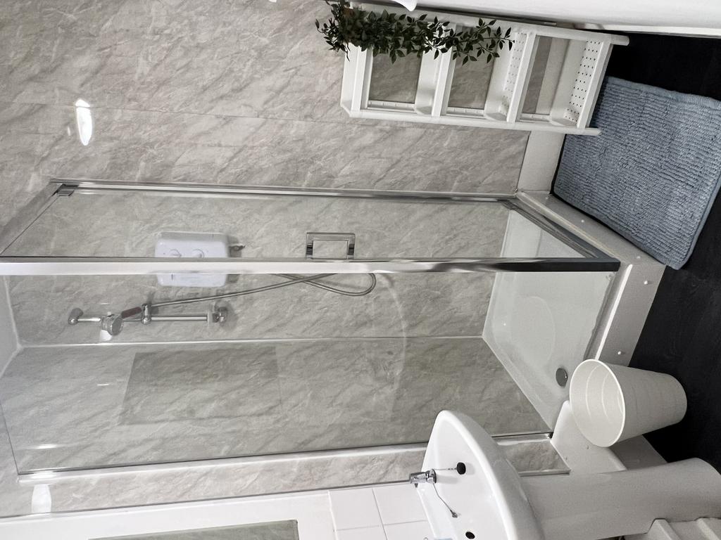 A modern bathroom featuring a spacious shower a...
