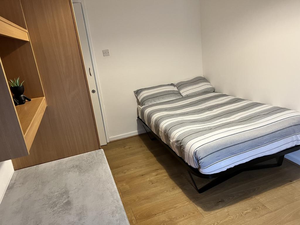 This cozy double bedroom features a comfortable...