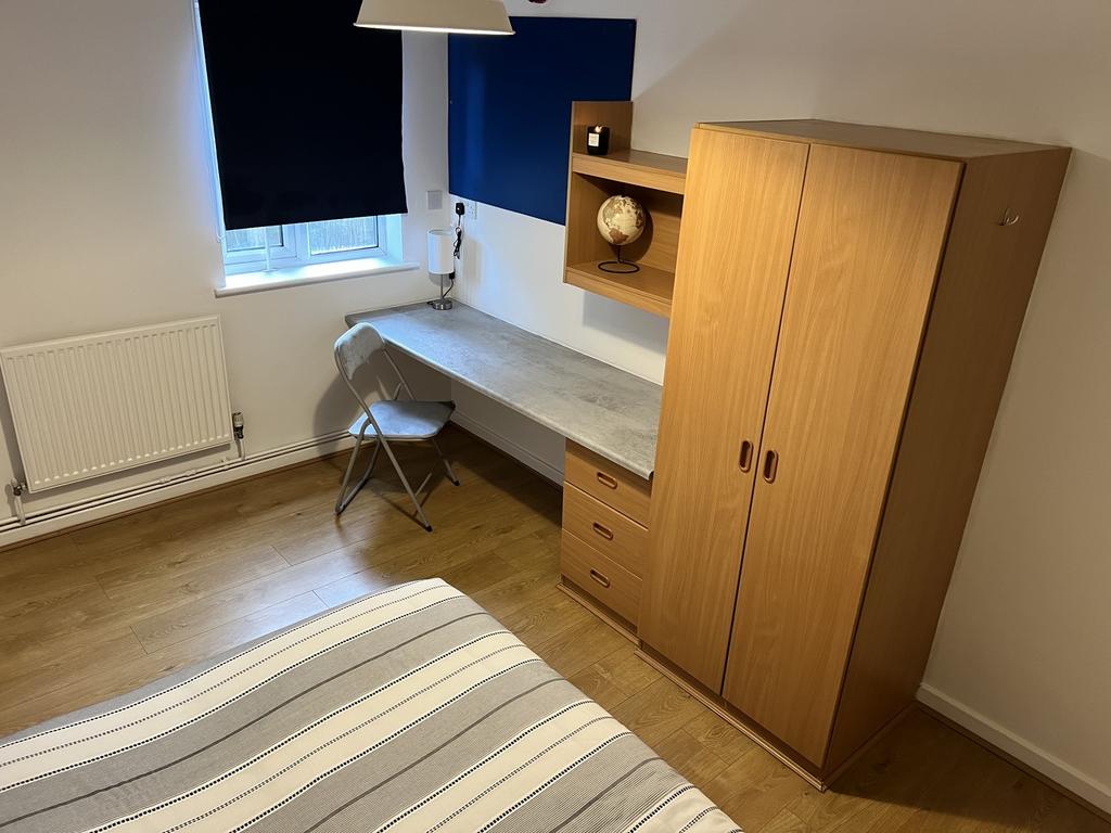 This inviting double bedroom features a cozy at...