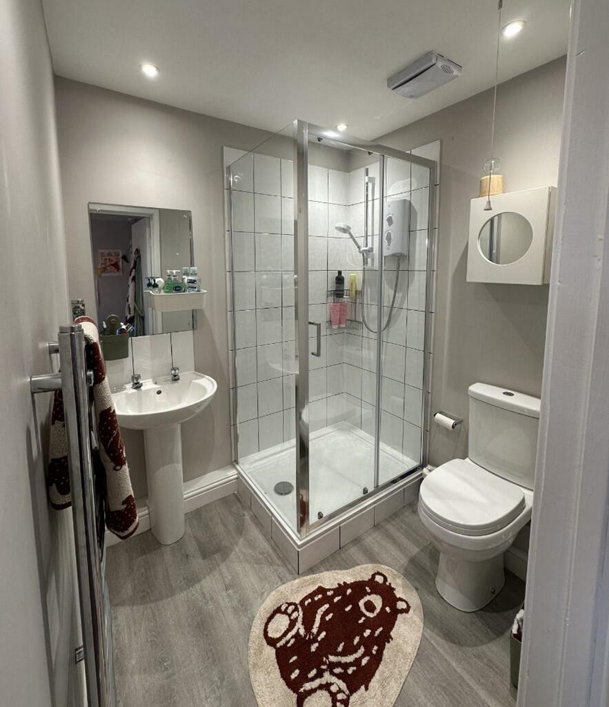 A modern bathroom featuring a sleek glass showe...