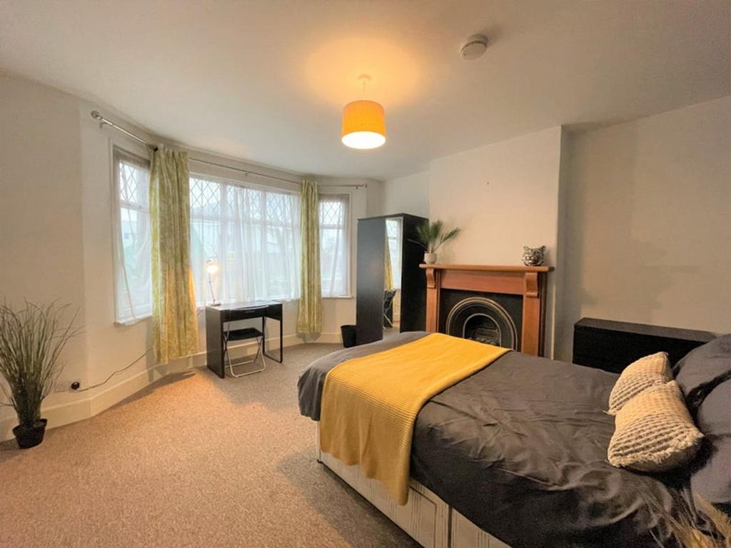 This spacious double bedroom features large win...