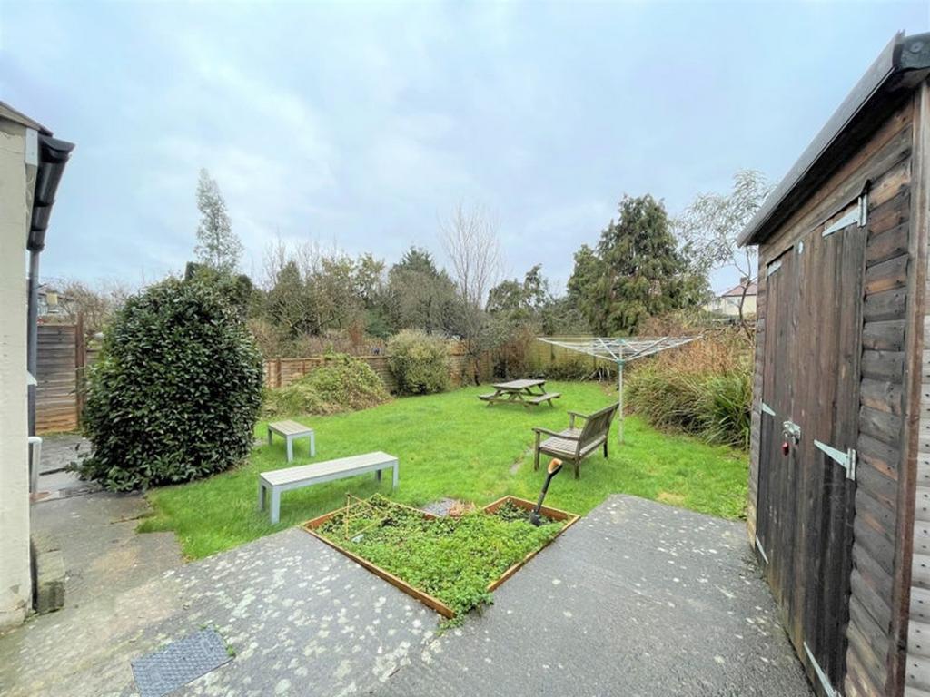 A charming garden space featuring green grass, ...
