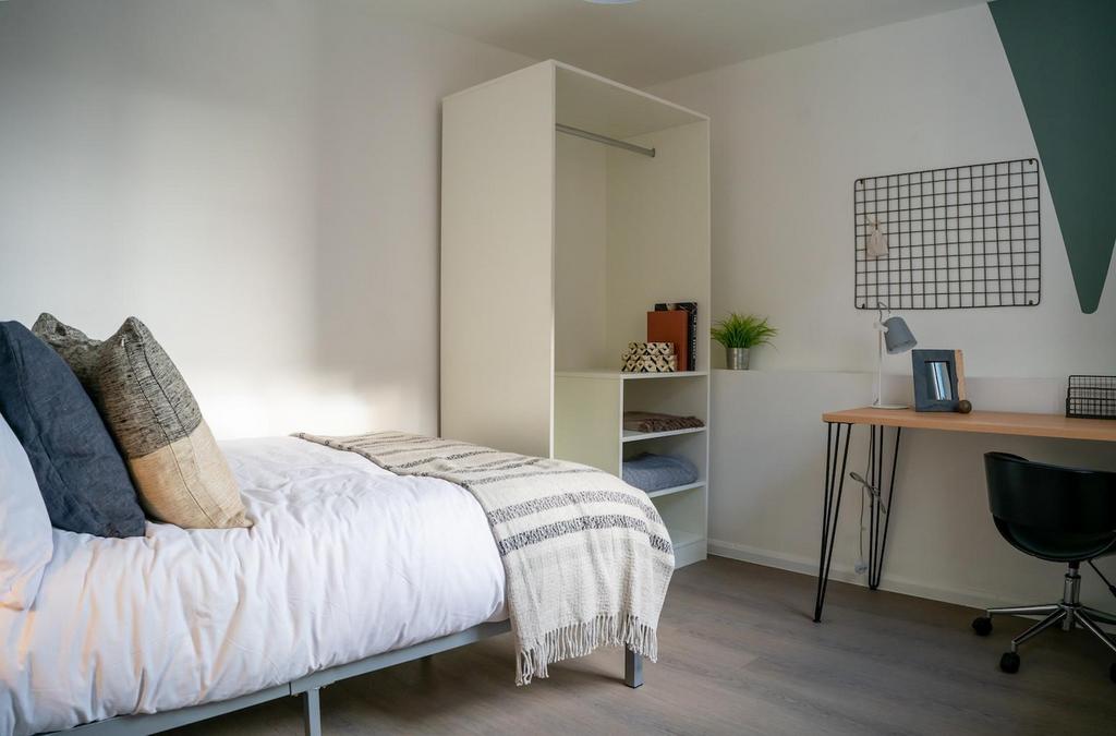 A bright and tidy double bedroom featuring a co...