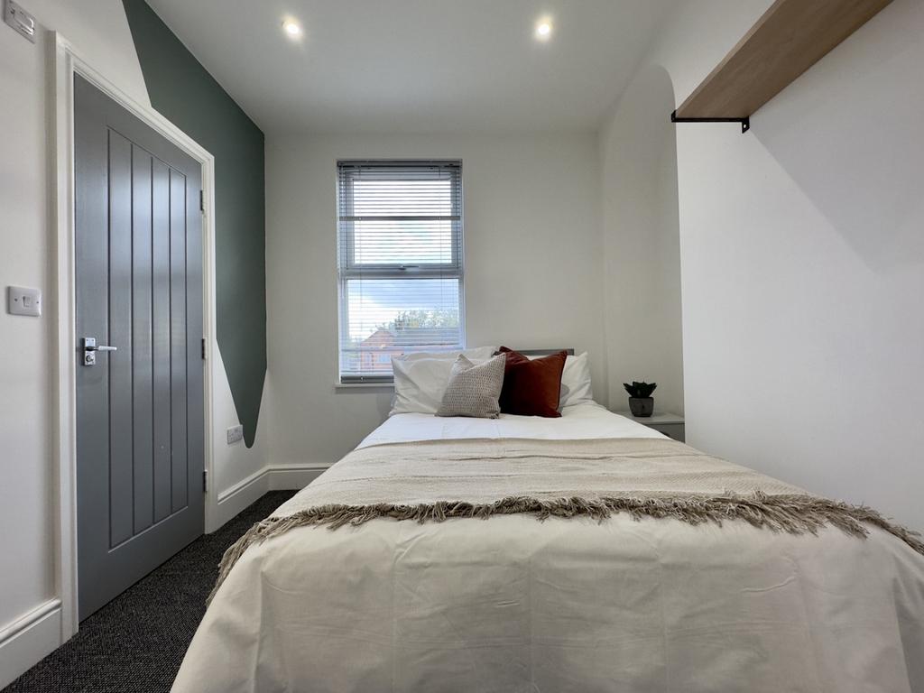 A bright and inviting double bedroom with moder...