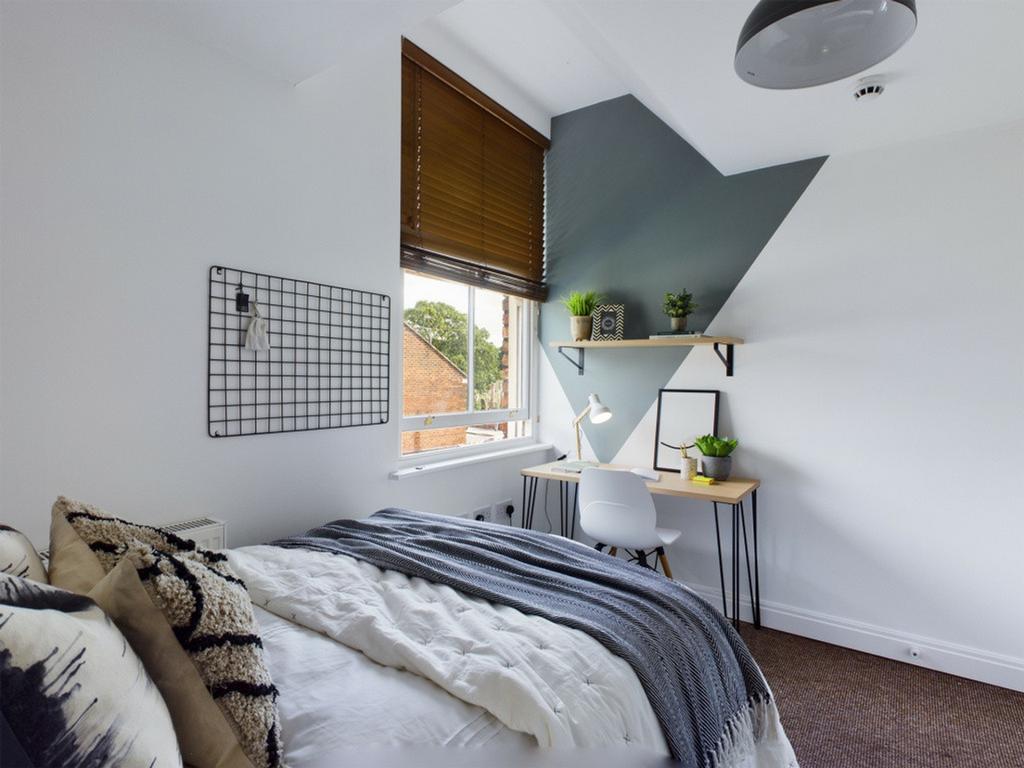 A bright and stylish double bedroom featuring a...