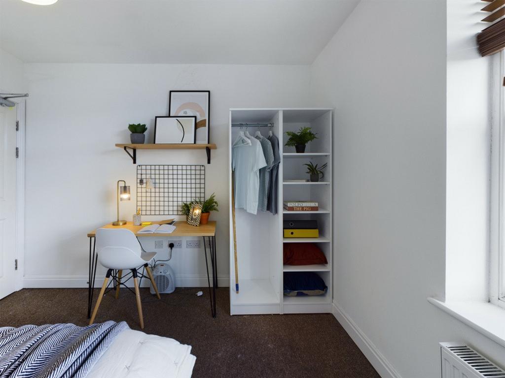 A bright and tidy double bedroom featuring a st...
