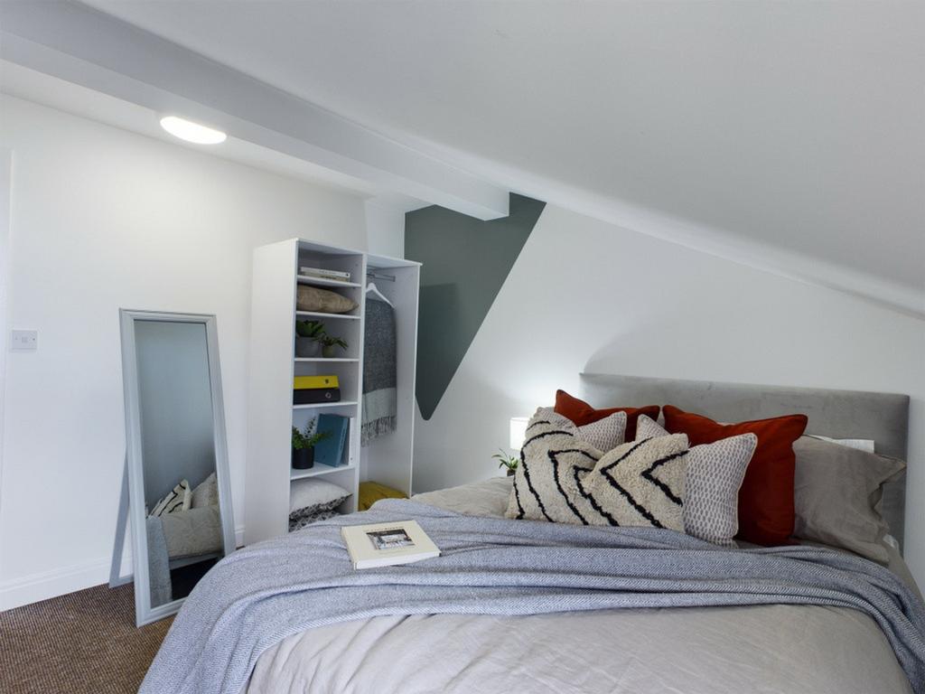 A cozy and stylish double bedroom with a comfor...