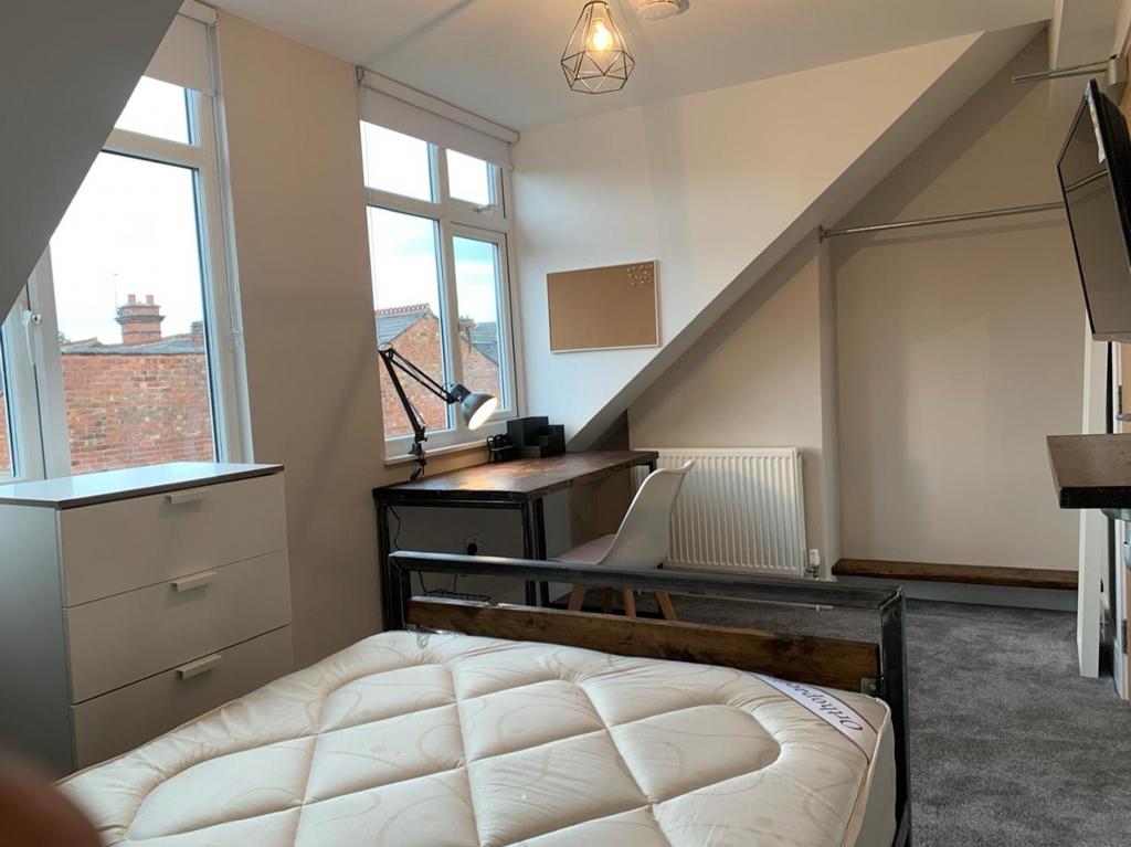 A bright and cozy double bedroom featuring larg...