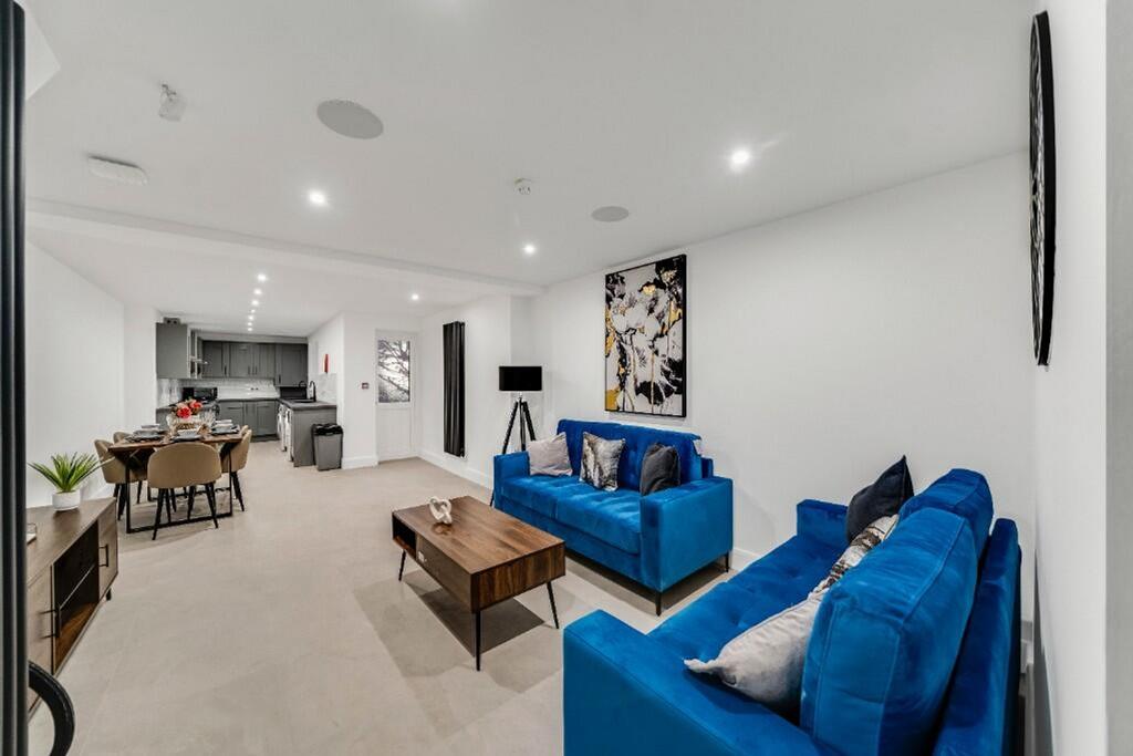 This spacious living room features modern blue ...