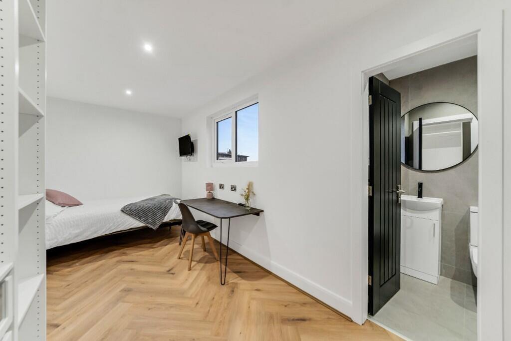 This spacious double bedroom features a comfort...