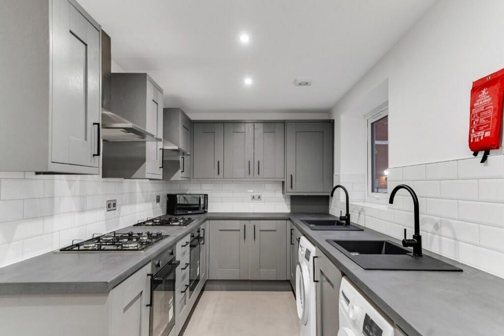 This modern kitchen features sleek gray cabinet...