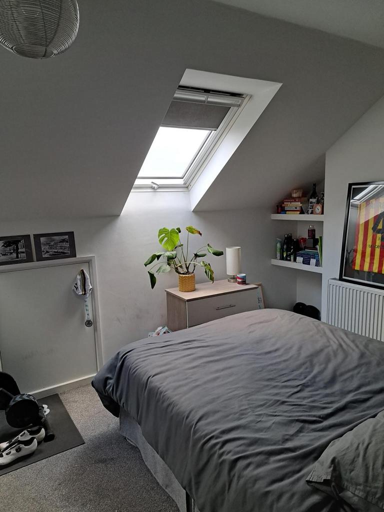 A cozy double bedroom featuring a skylight that...