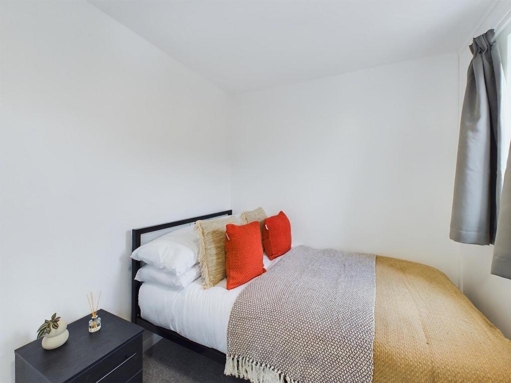 A bright and inviting double bedroom with styli...