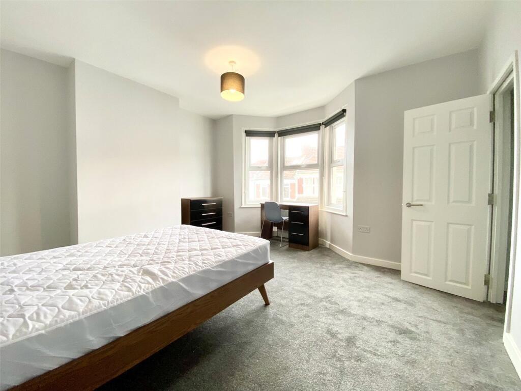 This spacious double bedroom features large win...