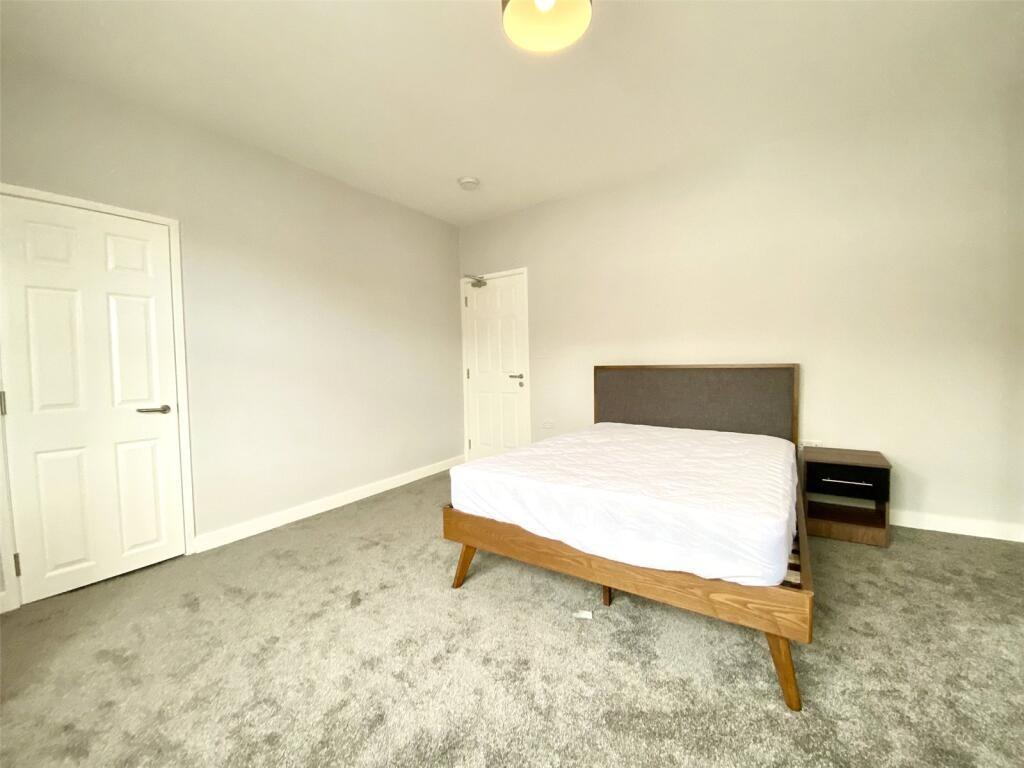Spacious double bedroom featuring a stylish woo...