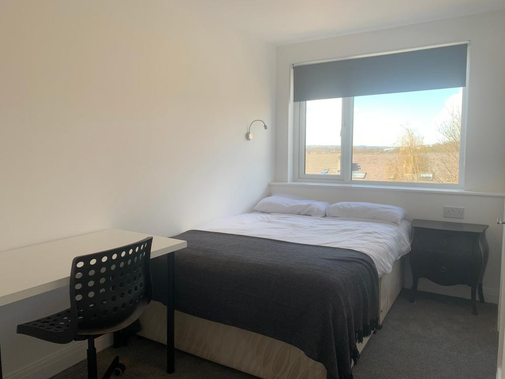 This inviting double bedroom features a comfort...