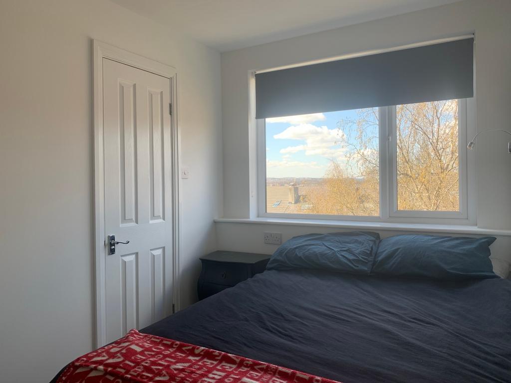 This cozy double bedroom features a large windo...