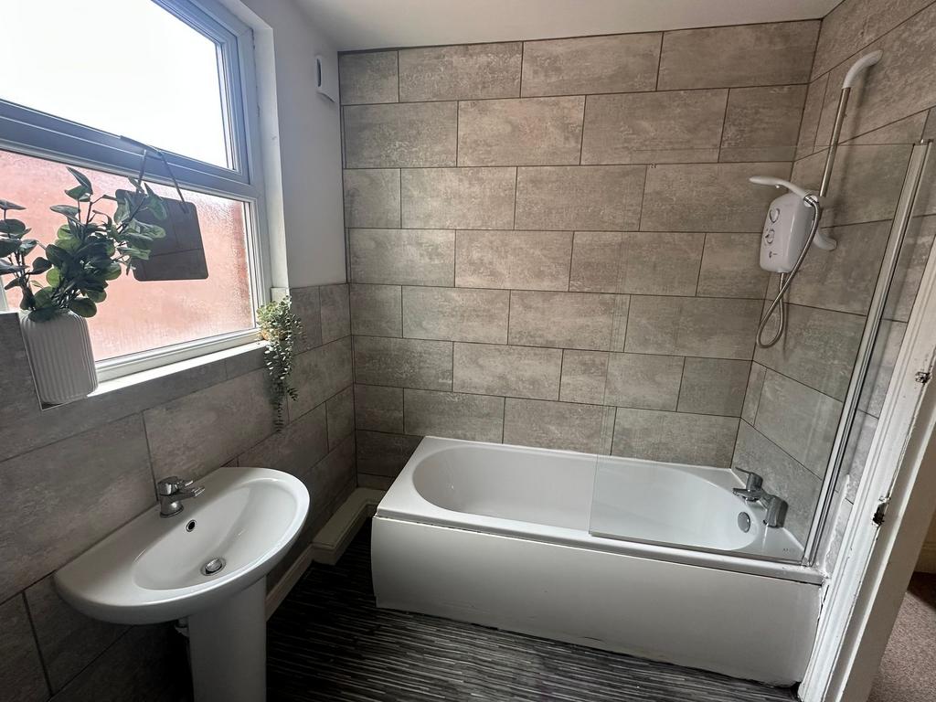 Bright and modern bathroom featuring a bathtub,...