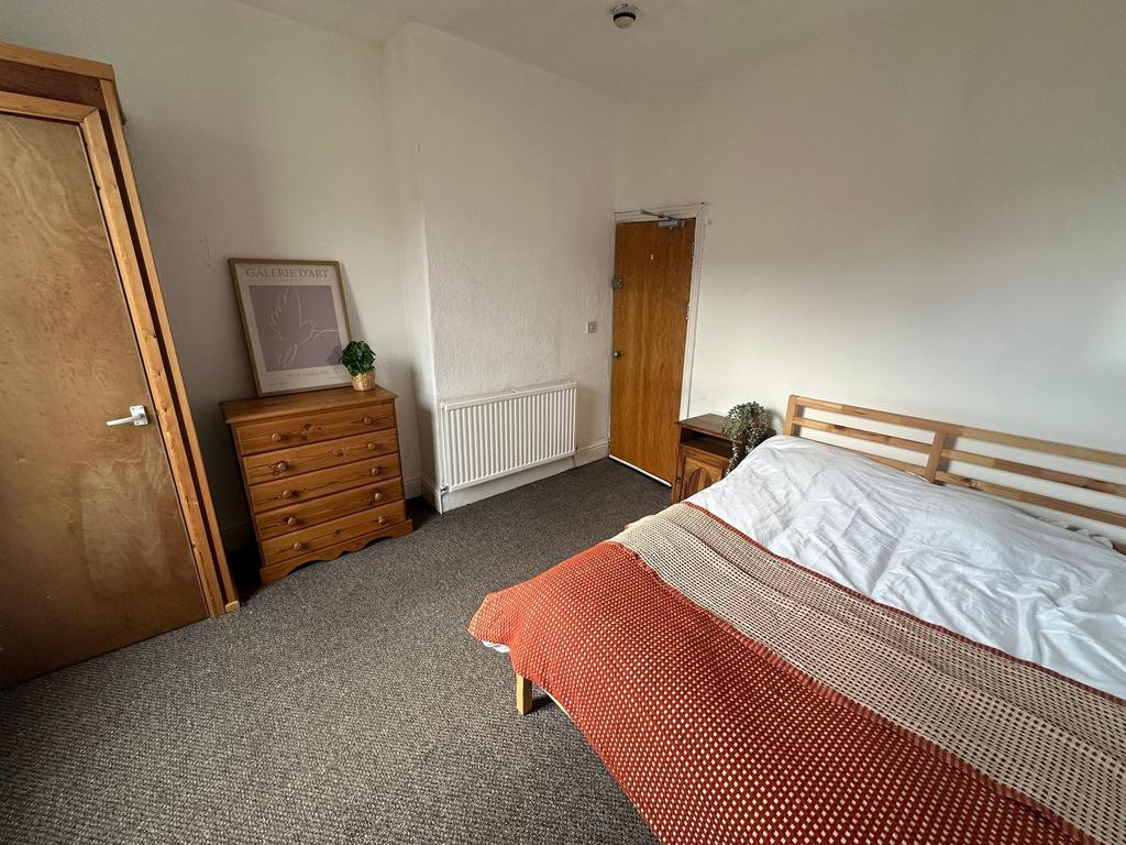 A comfortable double bedroom featuring a minima...
