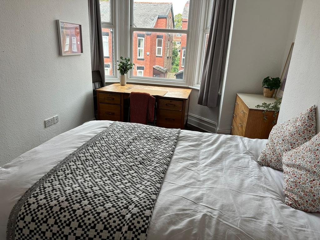 Bright and welcoming double bedroom featuring a...