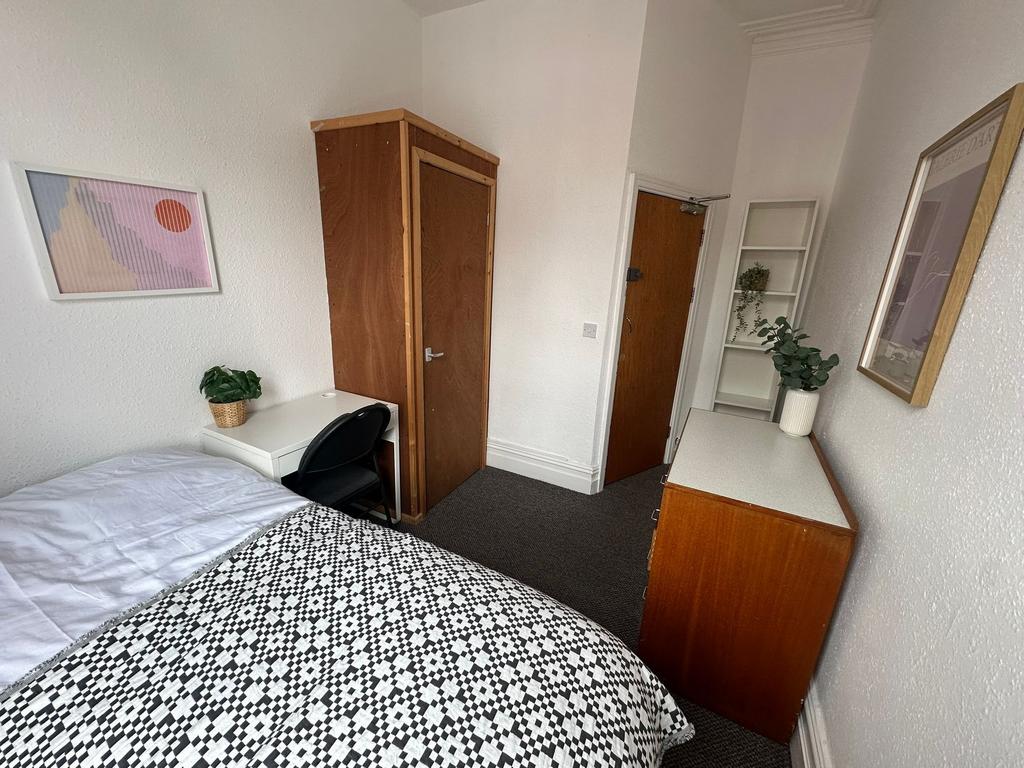 A cozy bedroom featuring a neatly made bed with...