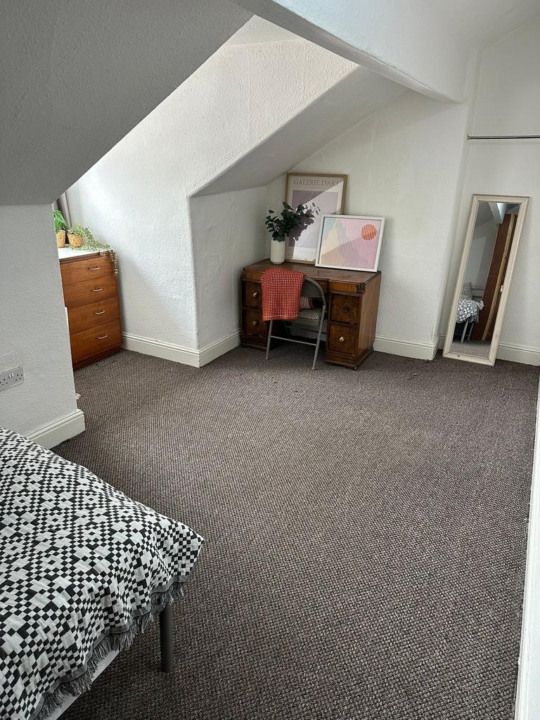 A cozy single bedroom with white textured walls...