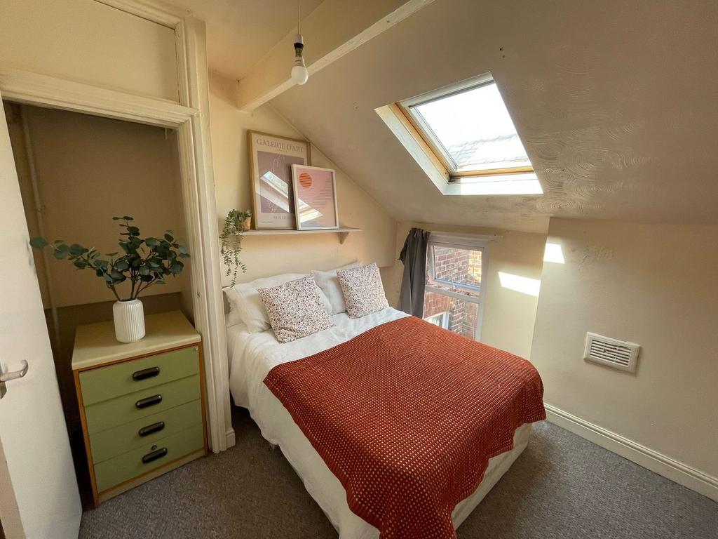 Cozy and inviting bedroom with natural light st...