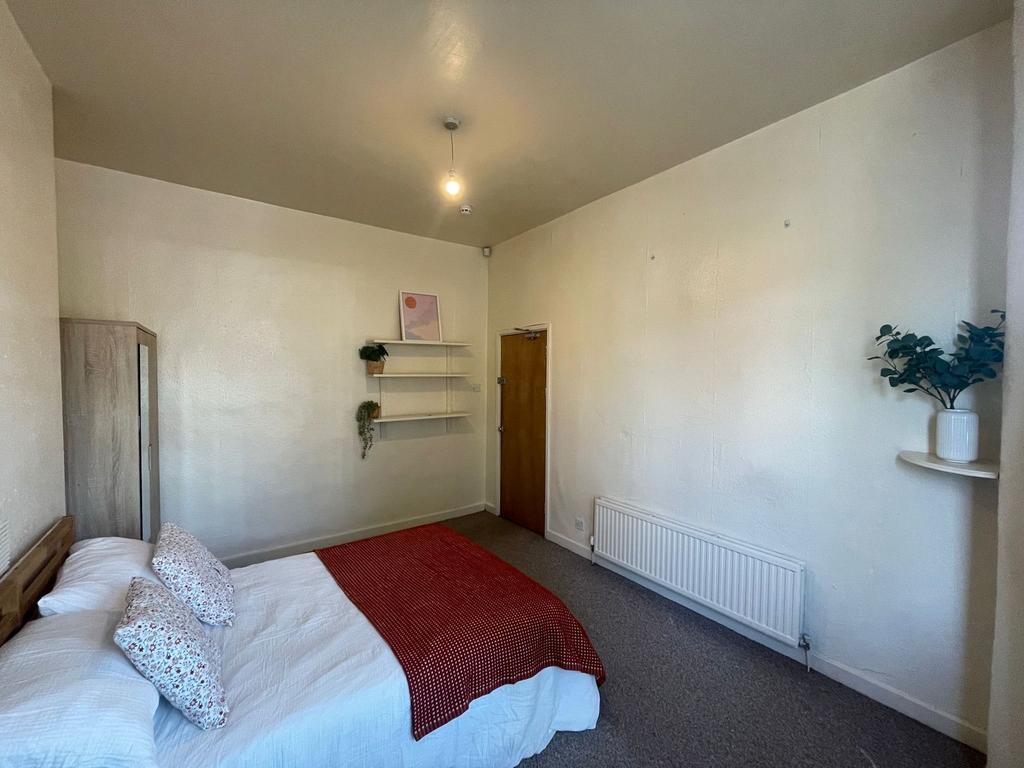 A cozy and well-maintained bedroom featuring a ...