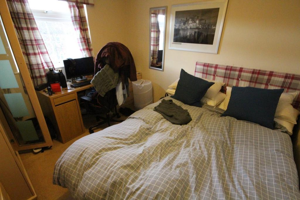 A cozy double bedroom featuring comfortable bed...