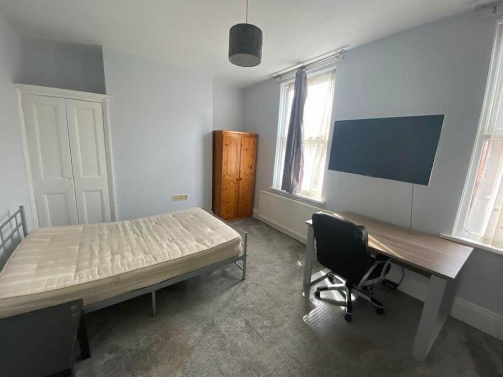 A spacious and bright double bedroom featuring ...