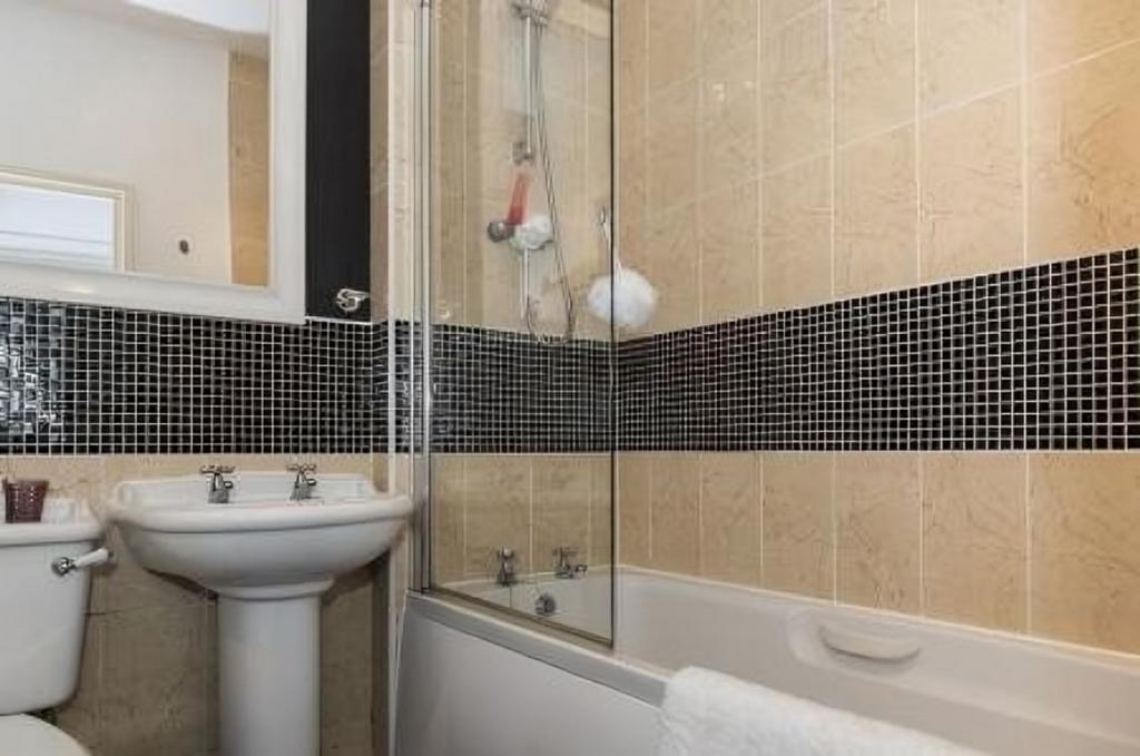 A well-maintained bathroom featuring a bathtub ...