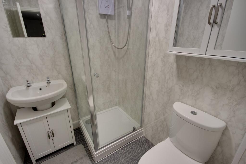 A pristine and modern bathroom featuring a spac...