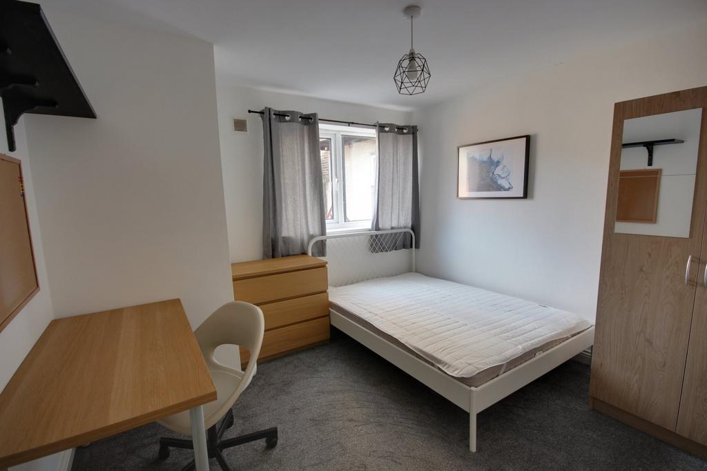 A bright and tidy double bedroom featuring a de...
