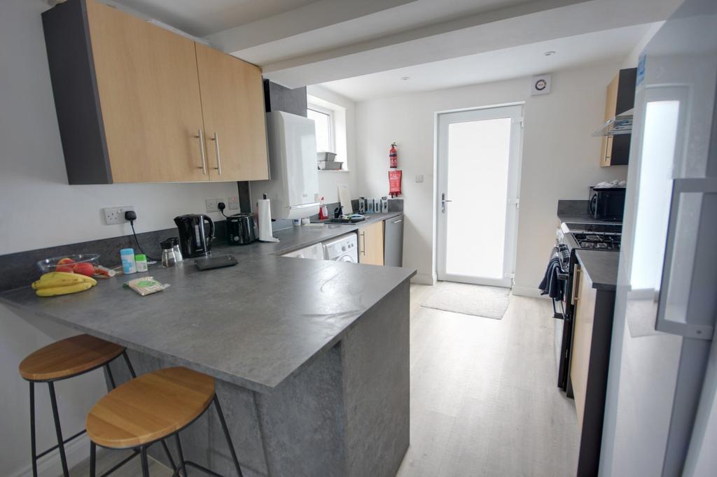 A modern and tidy kitchenette with ample natura...