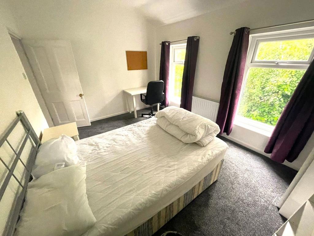 A bright and inviting double bedroom with ample...