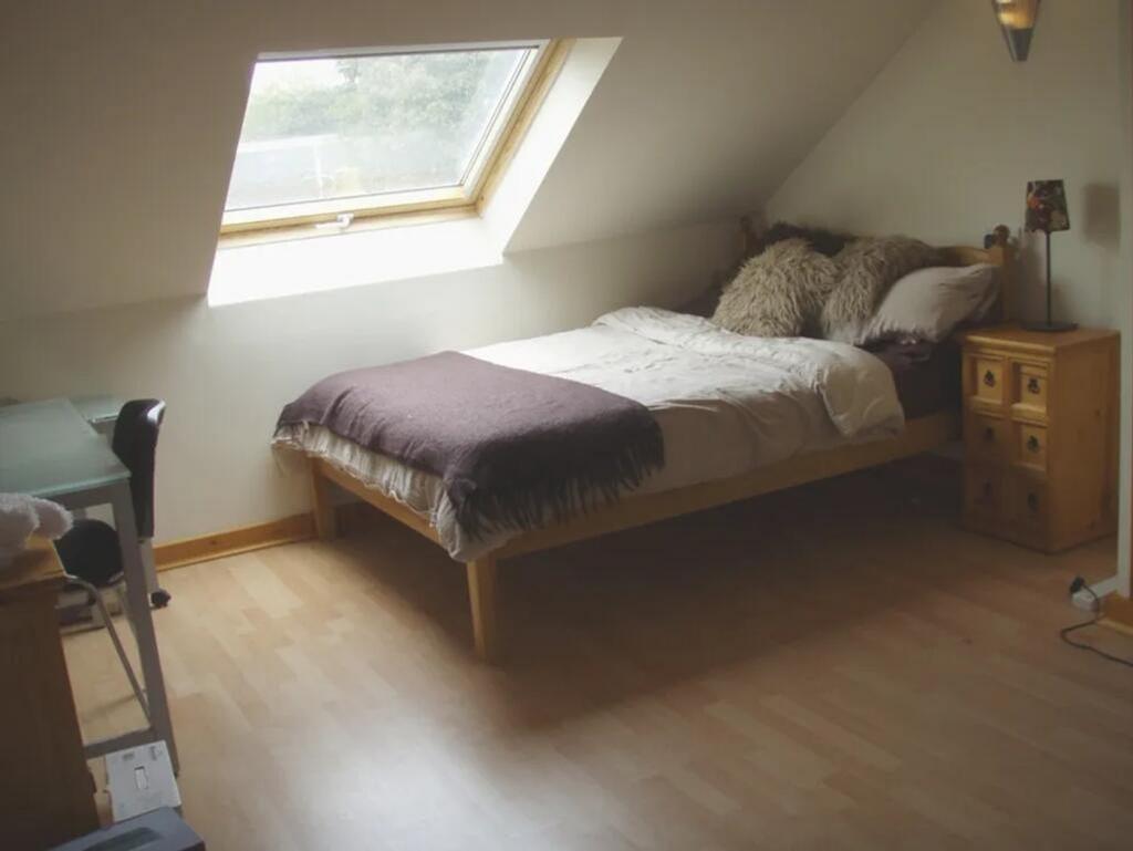A cozy double bedroom featuring a comfortable b...