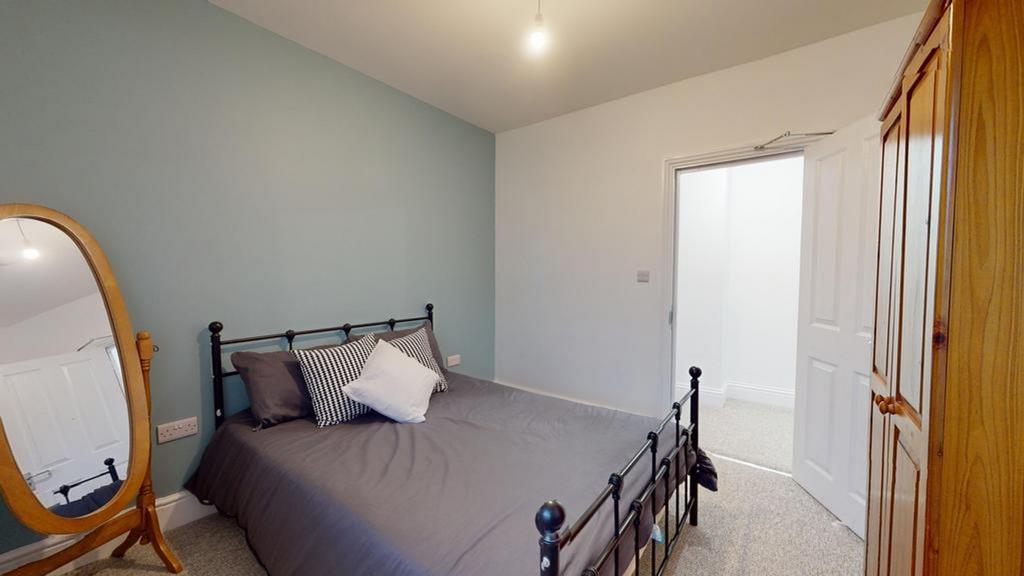 A spacious and clean double bedroom with stylis...