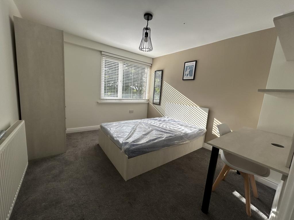 A bright and spacious double bedroom with moder...