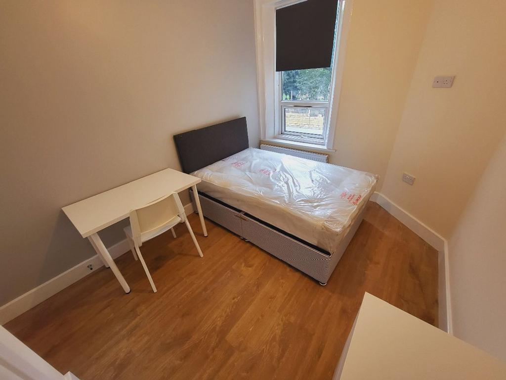 This cozy double bedroom features ample natural...