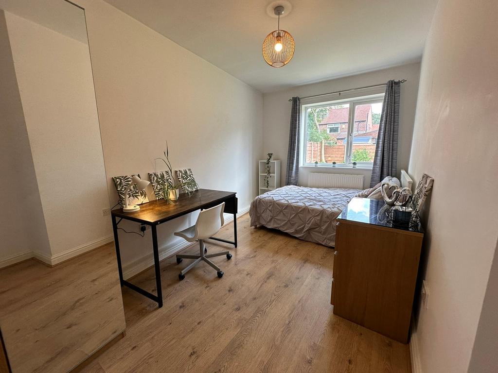 This inviting double bedroom features a comfort...
