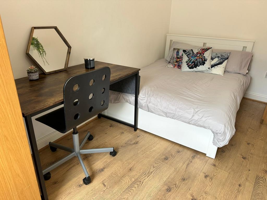 This inviting double bedroom features a comfort...