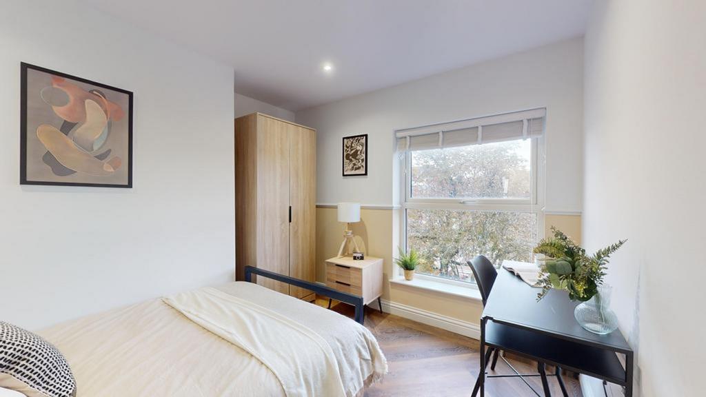 A bright and tidy double bedroom featuring mode...